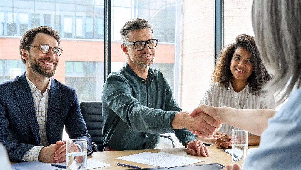Business team shaking hands tablet