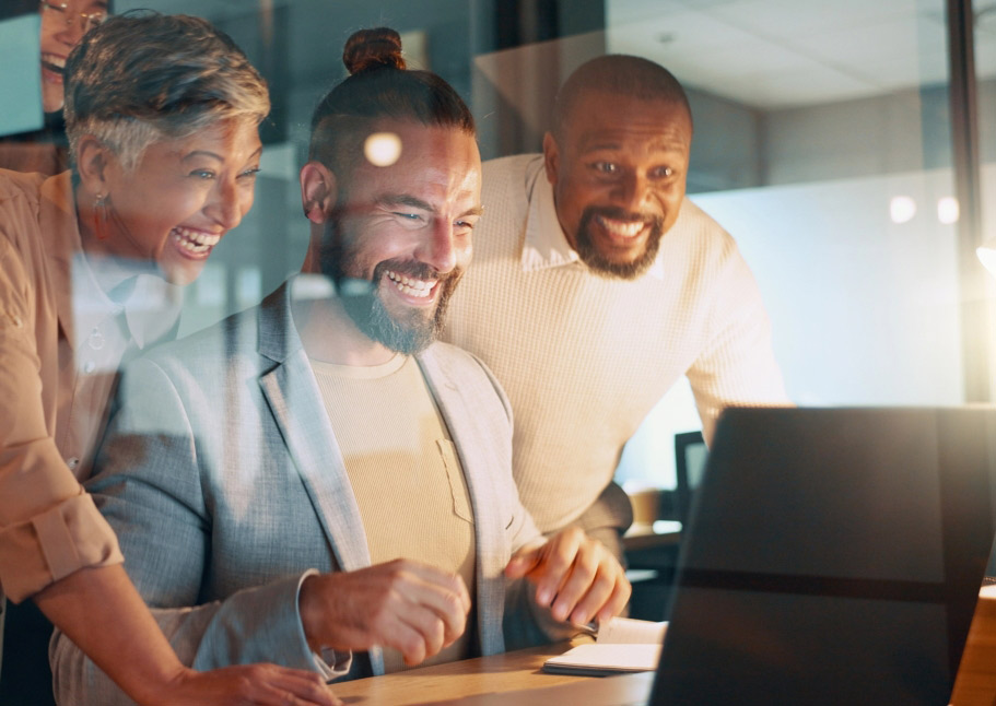 Excited business team looking at laptop