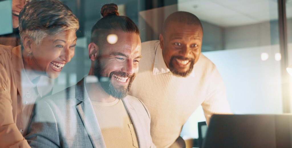 Excited business team looking at laptop tablet