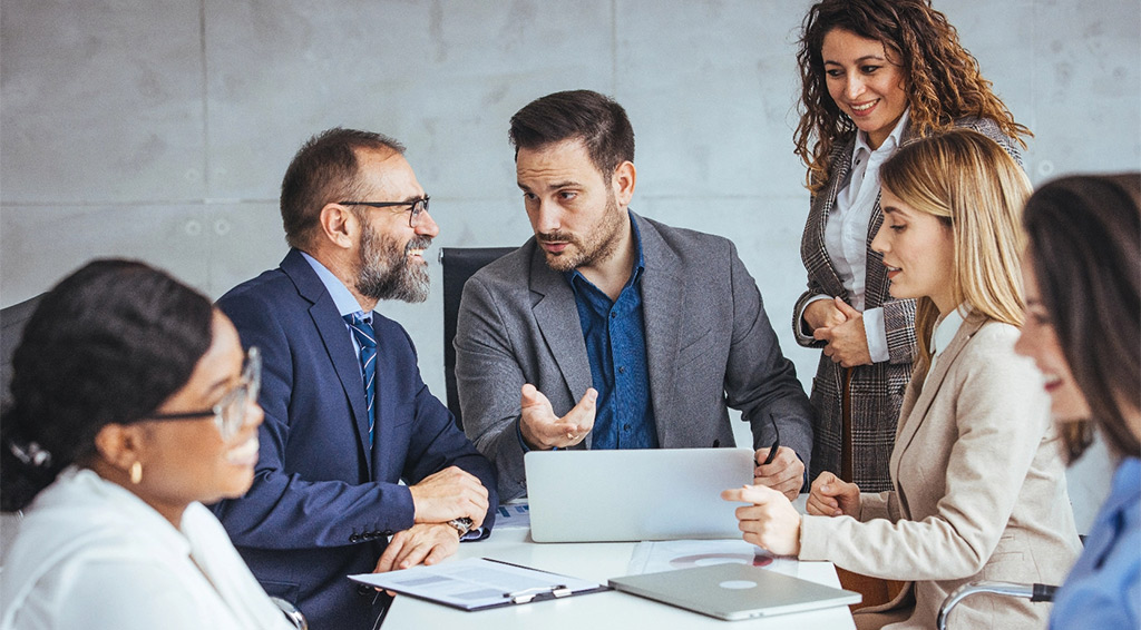 Group of diverse business professionals discuss strategies tablet