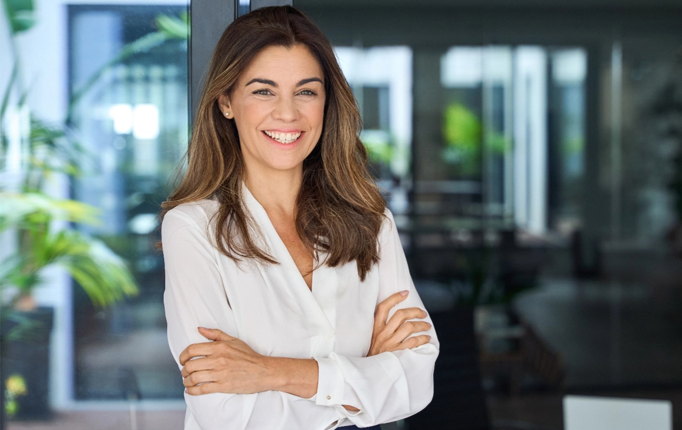 Middle aged business woman smiling with arms folded tablet