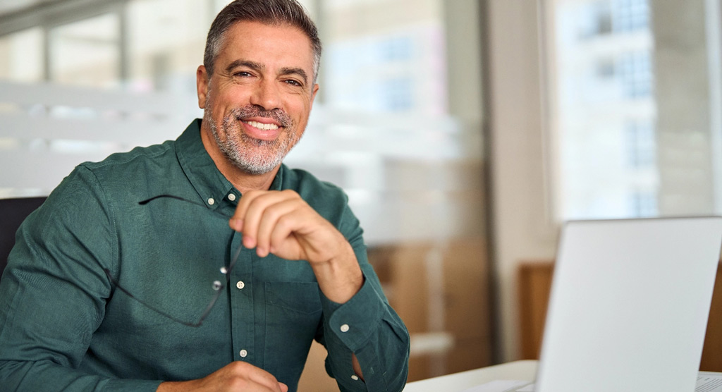 Middle aged professional man at desk left side tablet