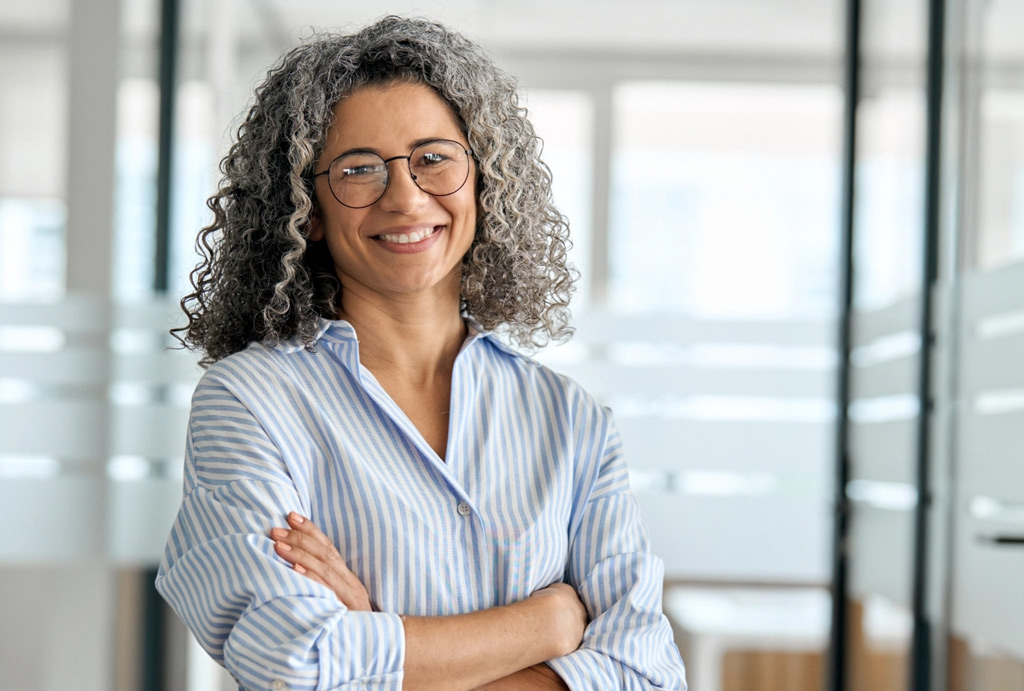Middle aged professional woman with arms folded tablet