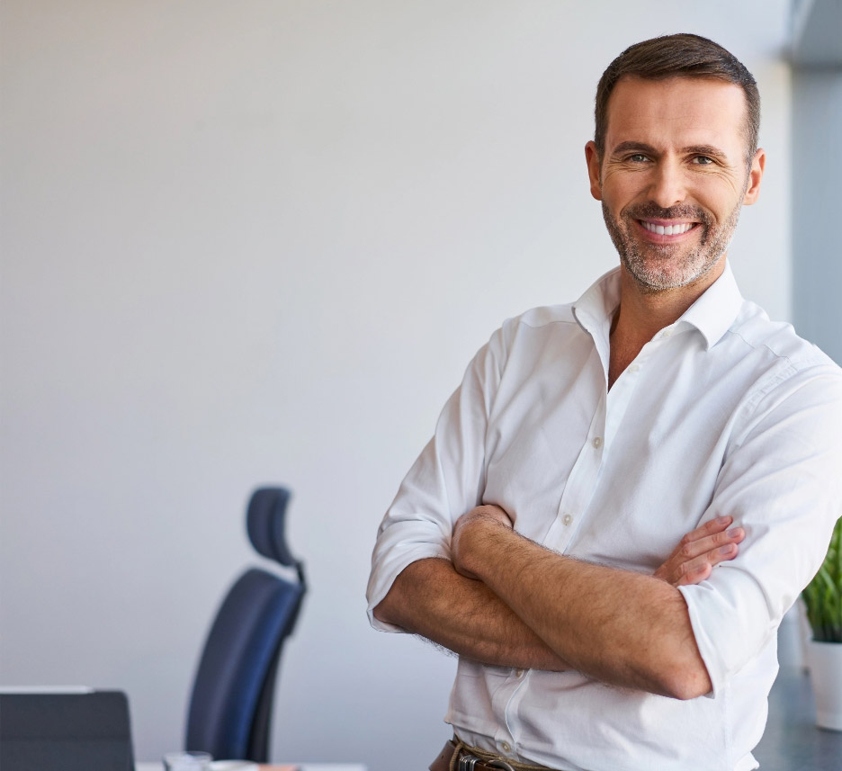 Smiling businessman standing in corporate office