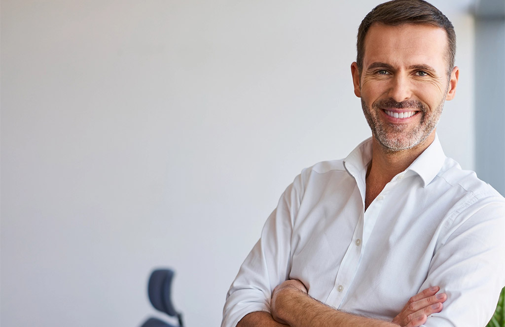 Smiling businessman standing in corporate office