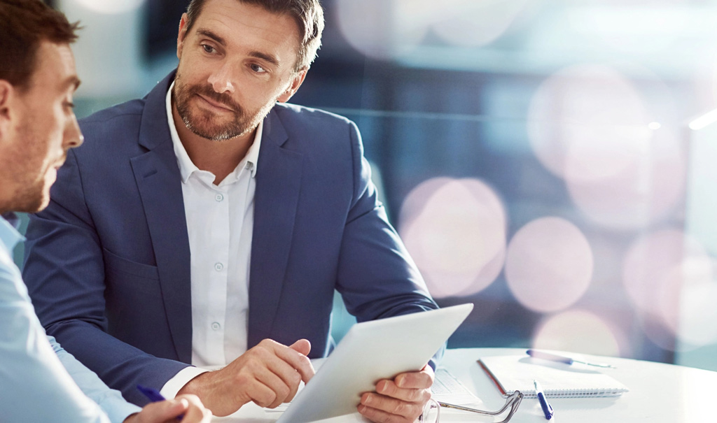 Two business men exchange ideas tablet