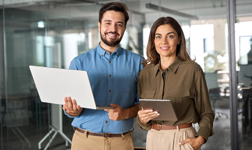 Two business professionals holding laptop tablet