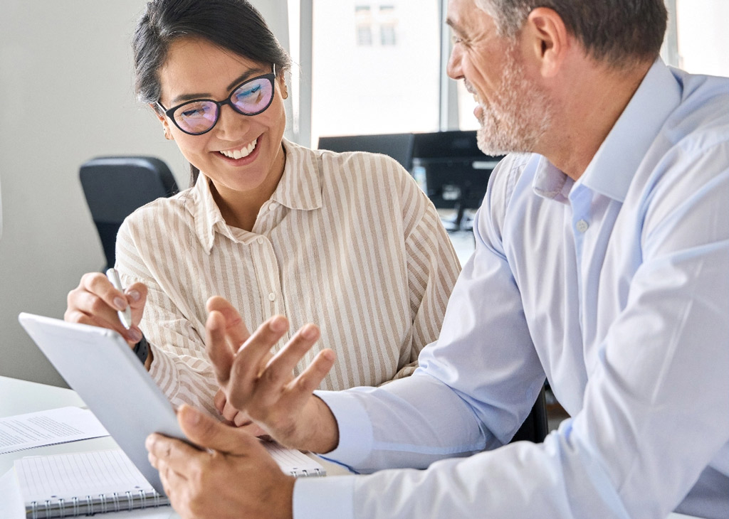 Two person team reviewing project documents tablet