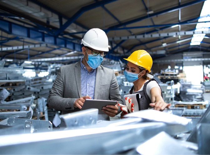Two professionals inspect production line ensuring safety
