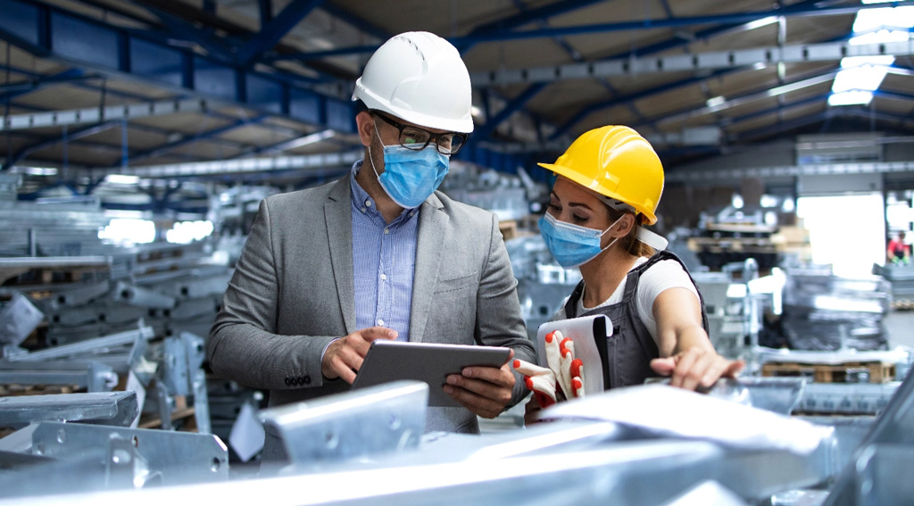 Two professionals inspect production line ensuring safety tablet